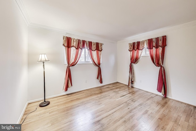 empty room featuring hardwood / wood-style floors, plenty of natural light, and ornamental molding