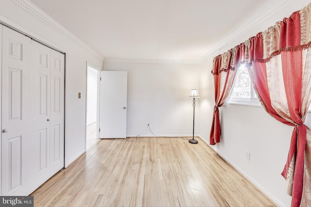 unfurnished bedroom featuring hardwood / wood-style floors, crown molding, and a closet