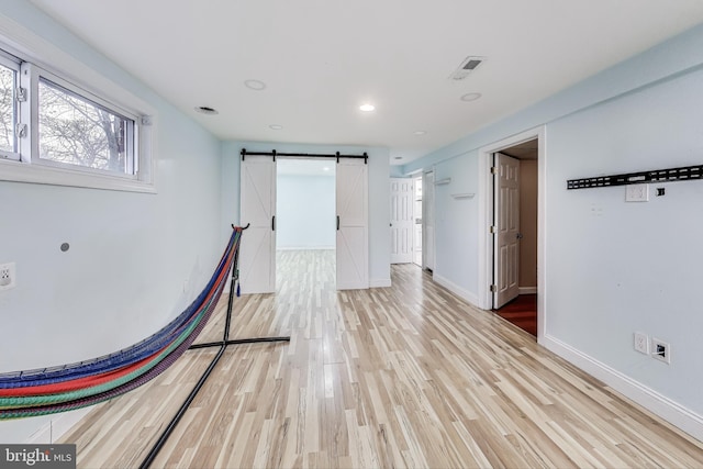 interior space with a barn door and light wood-type flooring