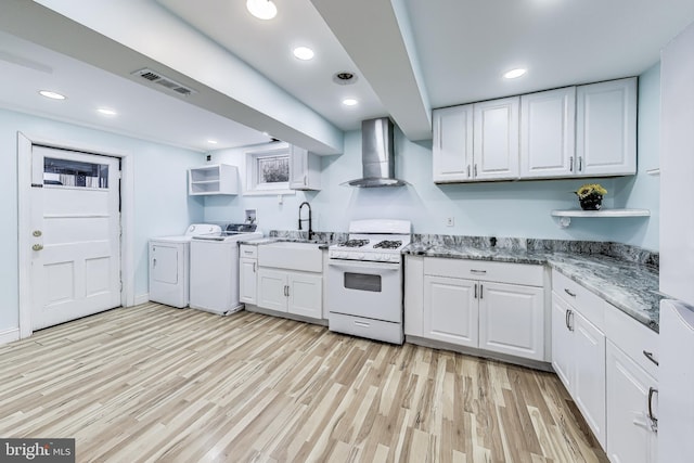 kitchen with white cabinetry, white gas stove, and wall chimney range hood