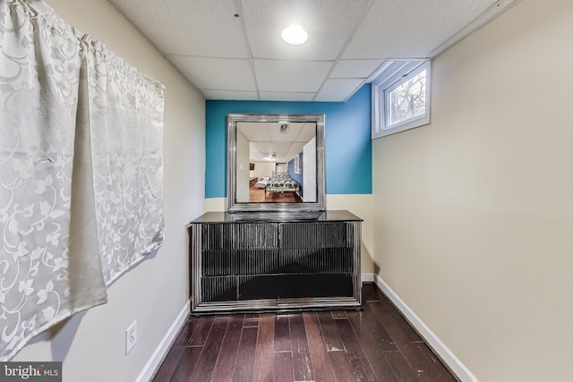 interior space featuring a paneled ceiling and dark wood-type flooring