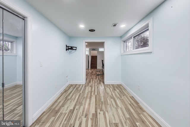 hallway with light hardwood / wood-style floors