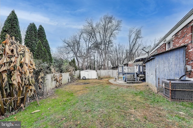 view of yard featuring cooling unit, a storage unit, and a deck