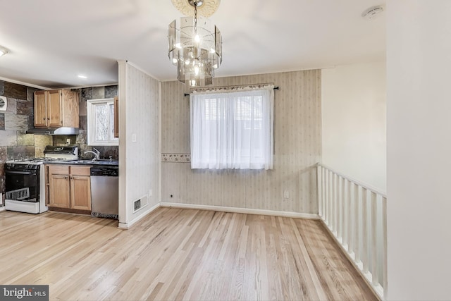 kitchen featuring dishwasher, an inviting chandelier, wooden walls, light wood-type flooring, and white gas stove