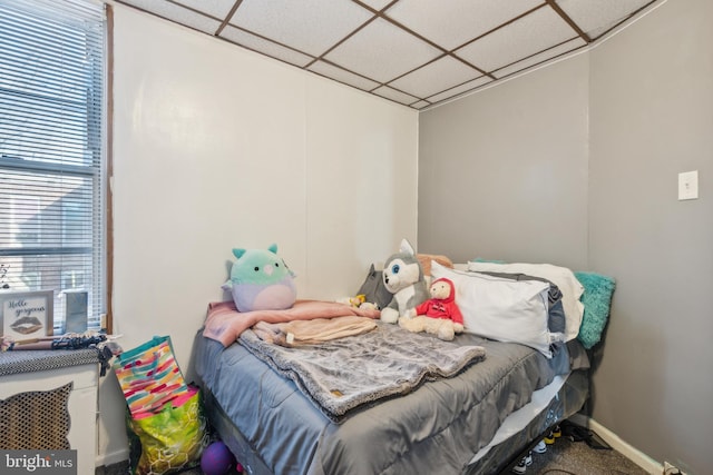 bedroom with a drop ceiling and carpet floors