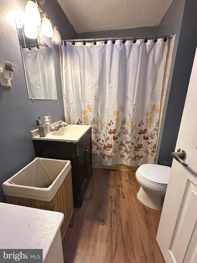 bathroom featuring toilet, sink, a textured ceiling, and hardwood / wood-style flooring