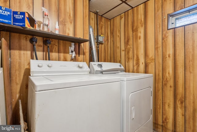 laundry area featuring washer and clothes dryer and wooden walls