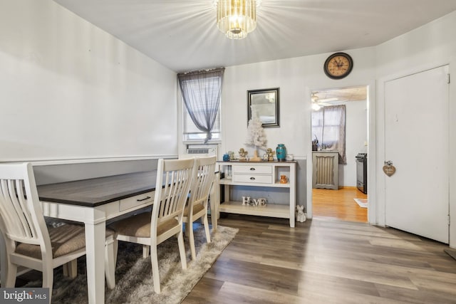 dining space with hardwood / wood-style floors, ceiling fan with notable chandelier, and a wealth of natural light