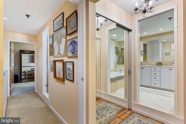 corridor featuring an inviting chandelier and light tile patterned floors