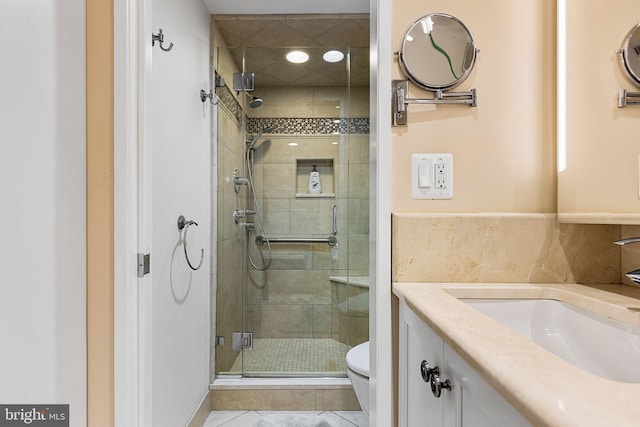 bathroom with vanity, toilet, an enclosed shower, and tile patterned flooring