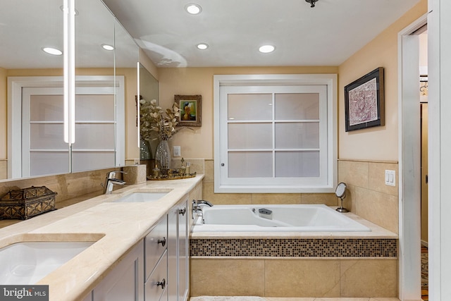 bathroom with vanity and a relaxing tiled tub