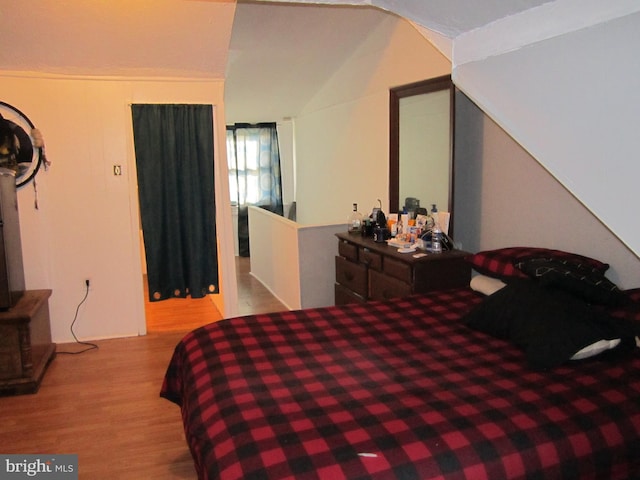 bedroom featuring light hardwood / wood-style floors and vaulted ceiling