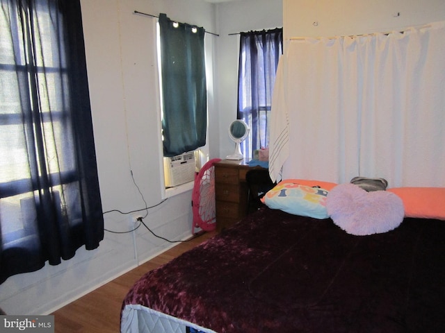 bedroom with hardwood / wood-style floors and cooling unit