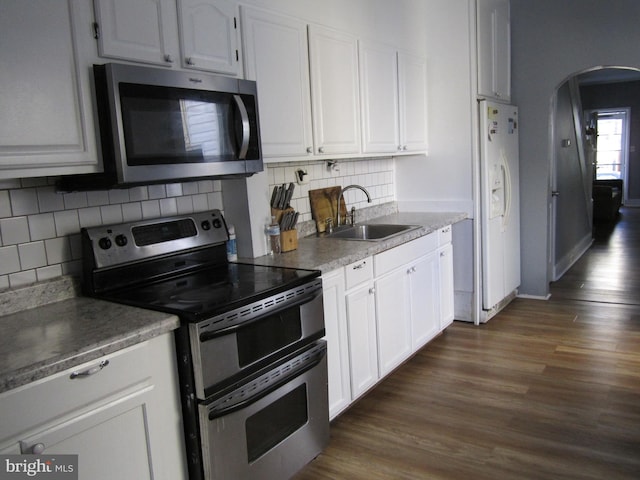 kitchen featuring dark hardwood / wood-style flooring, backsplash, stainless steel appliances, sink, and white cabinets