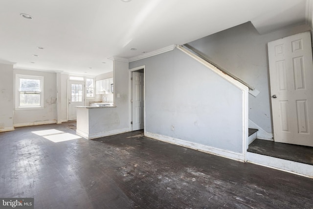 unfurnished living room with dark hardwood / wood-style floors and crown molding