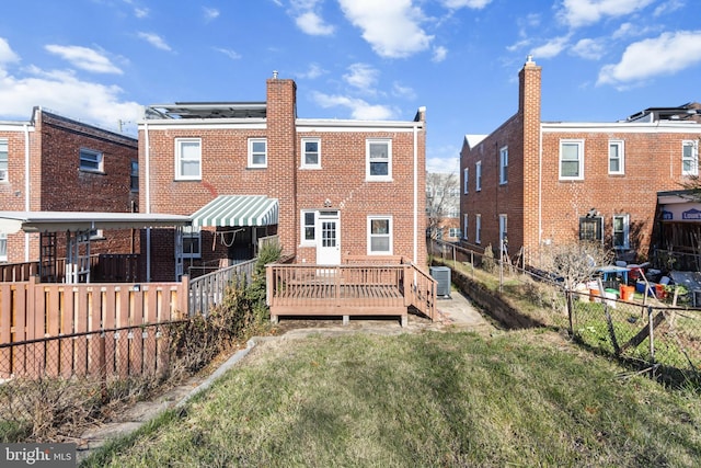 back of property featuring central air condition unit, a deck, and a lawn