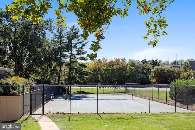 view of tennis court featuring a lawn