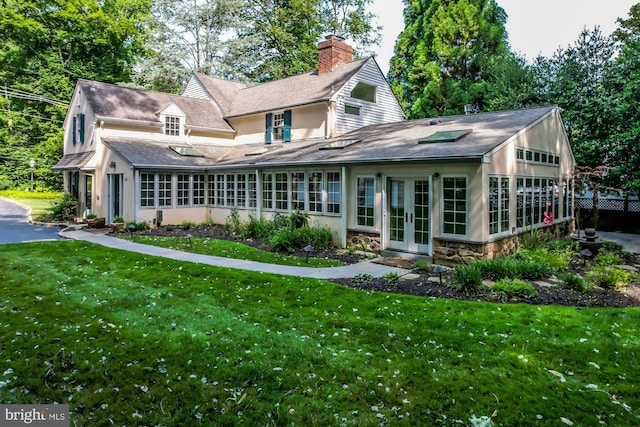 rear view of house featuring a lawn and french doors