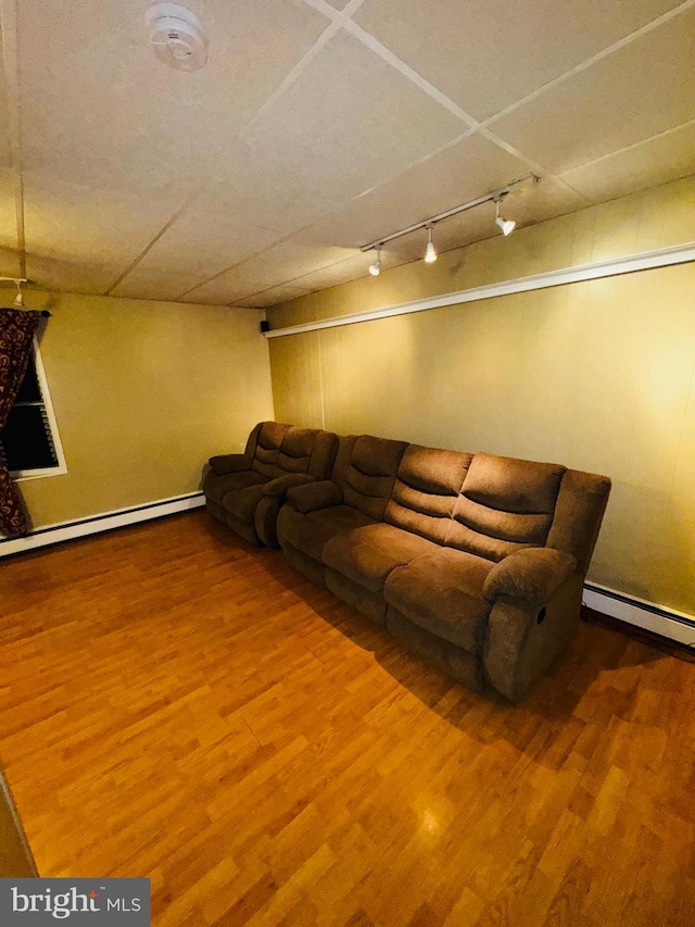 unfurnished living room with hardwood / wood-style floors and baseboard heating