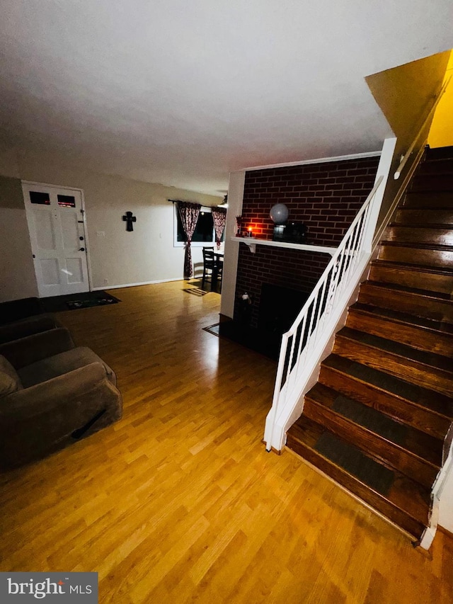 stairway featuring a fireplace and hardwood / wood-style flooring