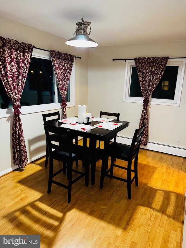 dining room featuring baseboard heating and hardwood / wood-style floors