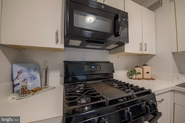 kitchen featuring white cabinetry and black appliances