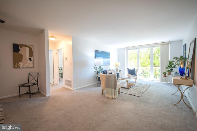 sitting room with expansive windows and light carpet