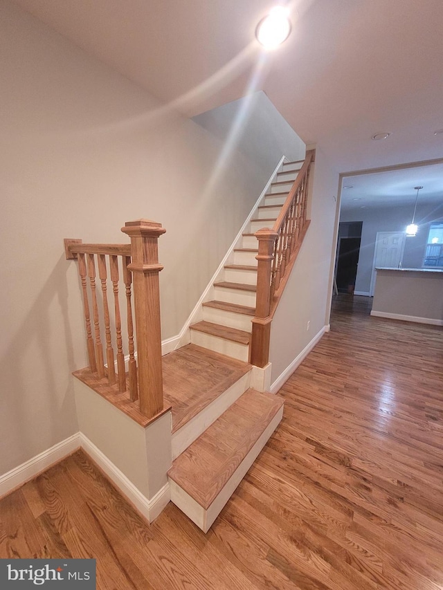 staircase with hardwood / wood-style flooring