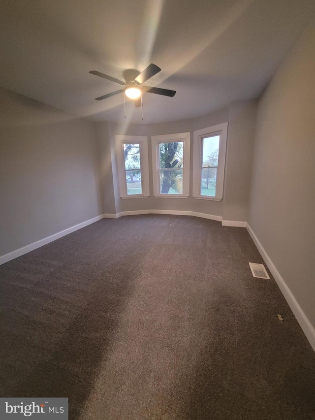 empty room featuring carpet, ceiling fan, and a healthy amount of sunlight