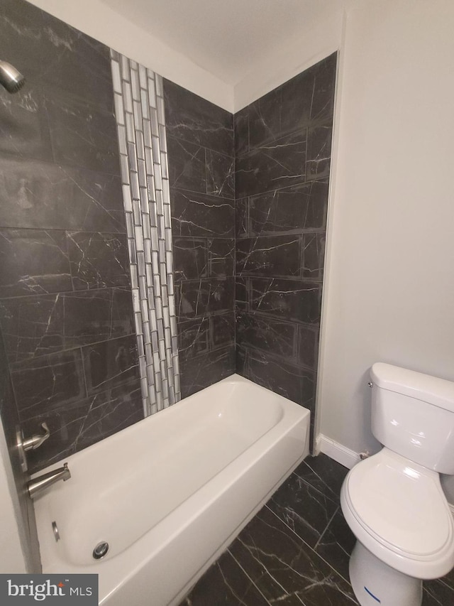 bathroom with tiled shower / bath combo and toilet