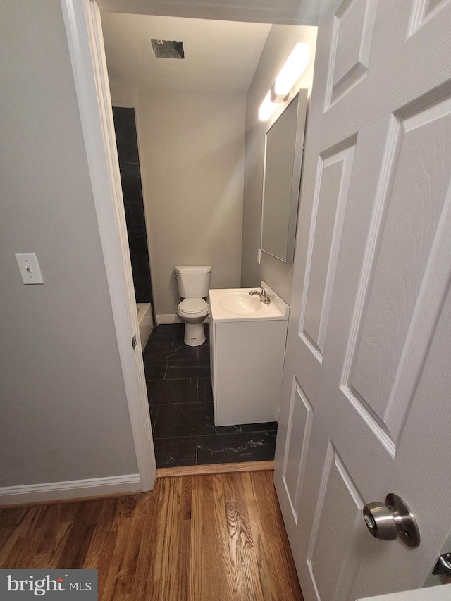 bathroom with hardwood / wood-style floors, vanity, and toilet