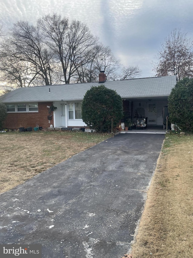 ranch-style house with a carport and a front lawn