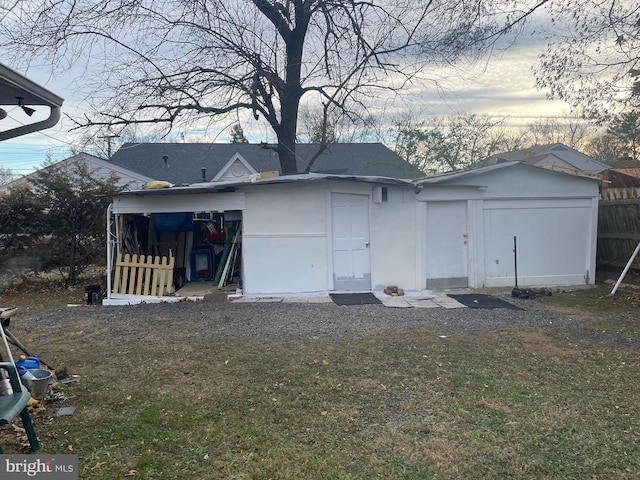 back house at dusk featuring a yard