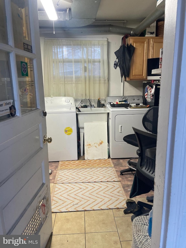 laundry room with light tile patterned flooring, cabinets, sink, and washing machine and dryer