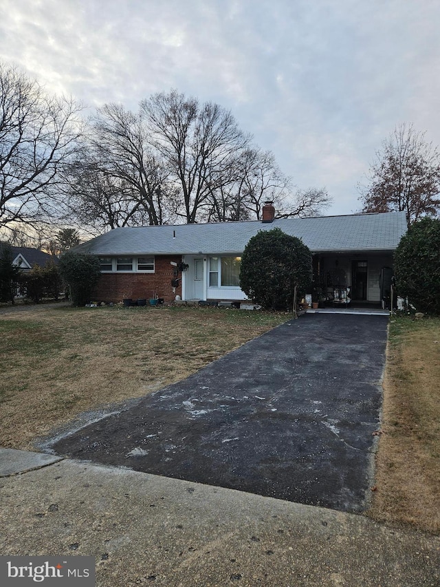 ranch-style house featuring a carport and a front yard