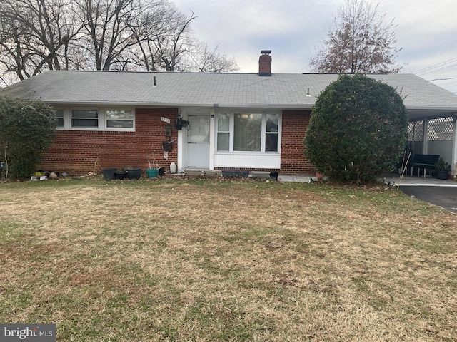 view of front of house with a carport and a front lawn