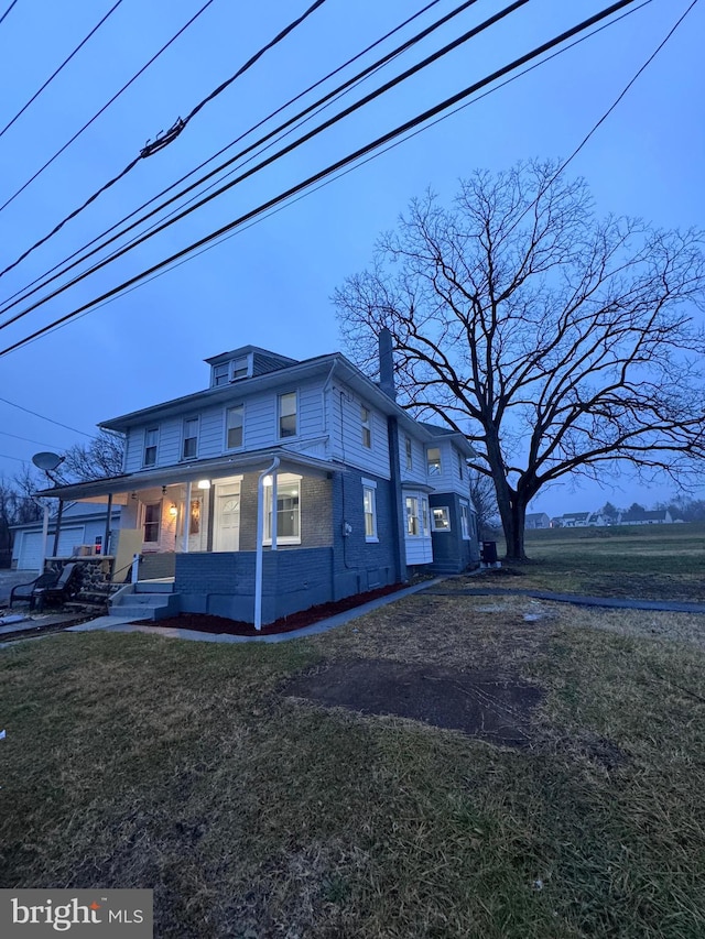 view of side of home featuring a yard and covered porch