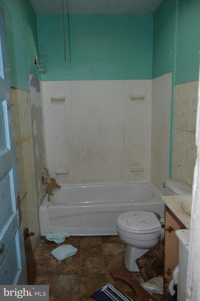 full bathroom with shower / tub combination, vanity, toilet, and tile walls