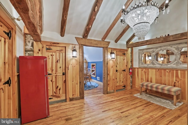 sitting room featuring wood walls, high vaulted ceiling, light hardwood / wood-style floors, a notable chandelier, and beam ceiling