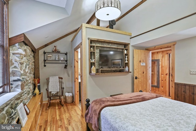 bedroom featuring wood-type flooring, wooden walls, and vaulted ceiling