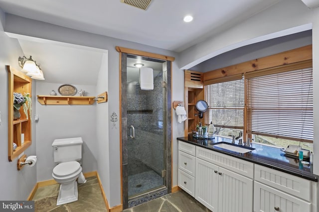 bathroom with vanity, toilet, and a shower with shower door