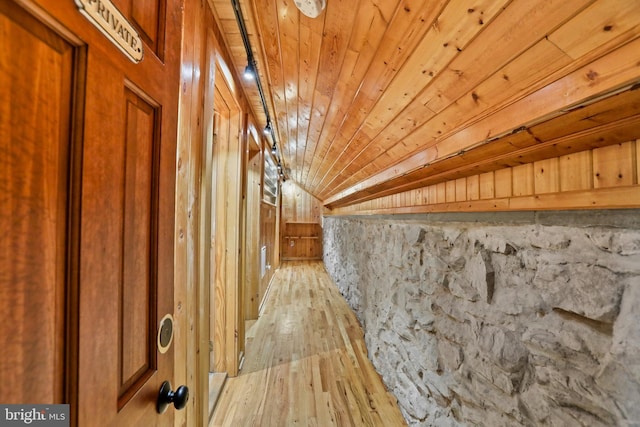 hall featuring wood walls, wooden ceiling, and light wood-type flooring