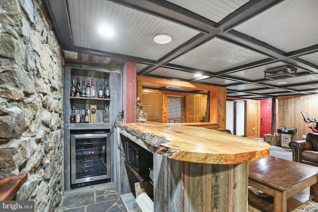 bar with wood counters, wood walls, wine cooler, and coffered ceiling