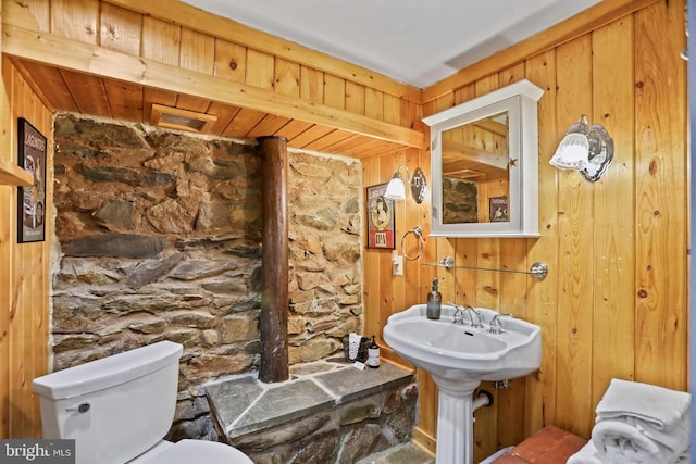 bathroom with wooden ceiling, toilet, wooden walls, and sink