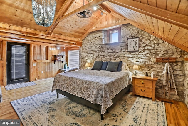 bedroom with vaulted ceiling with beams, wooden walls, wood-type flooring, and wooden ceiling