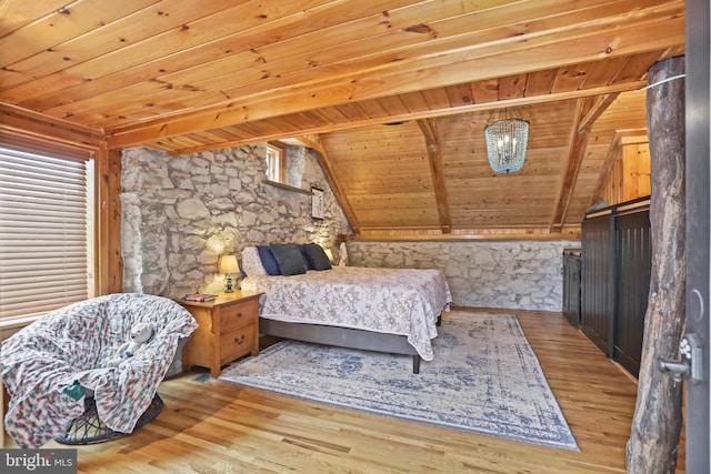 bedroom with lofted ceiling with beams, light hardwood / wood-style flooring, and wood ceiling