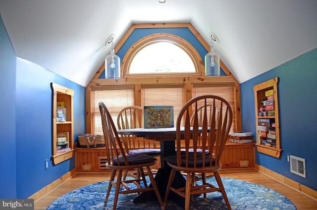 dining space with light hardwood / wood-style floors and lofted ceiling