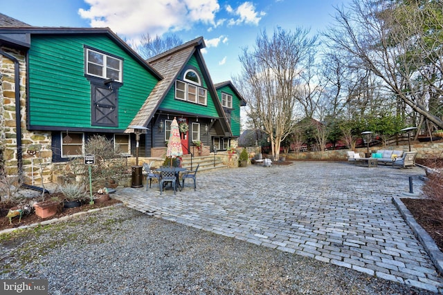 rear view of property featuring a patio and an outdoor hangout area