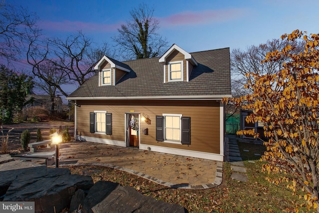 back house at dusk with a patio