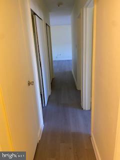 hallway with dark hardwood / wood-style flooring